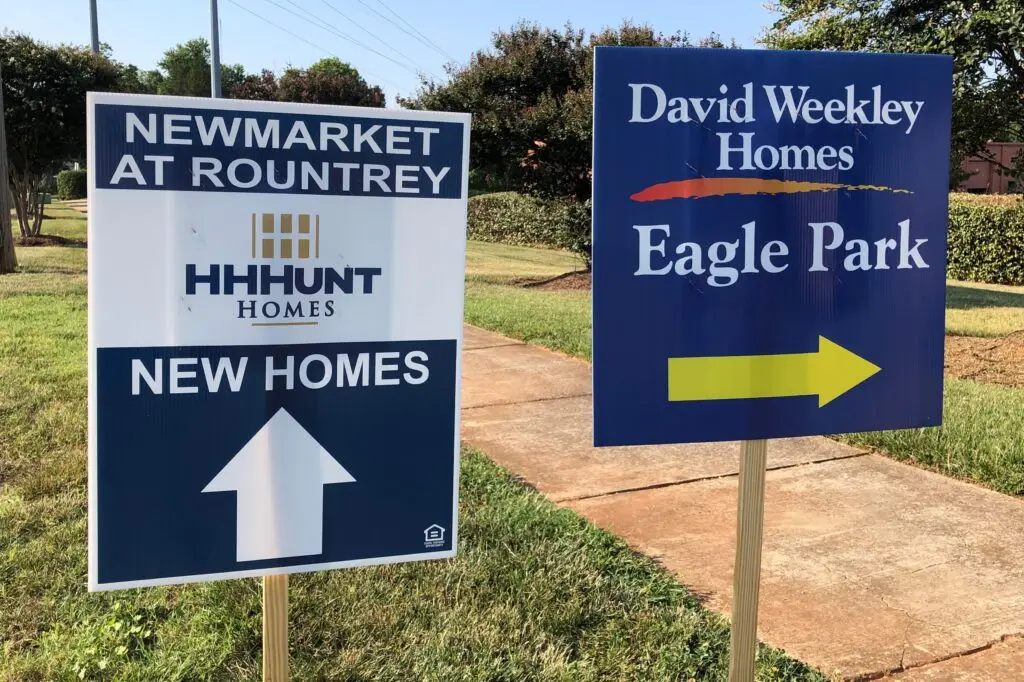 Weekend directional signs guiding homebuyers to a new home community