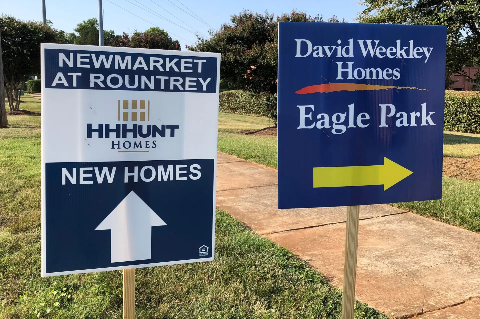 Weekend directional signs guiding homebuyers to a new home community